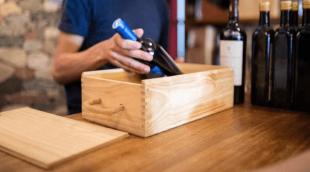 staff putting wine bottles in a case